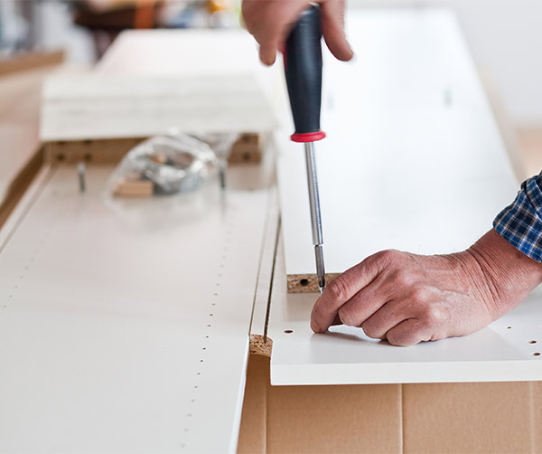 handyman assembling white furniture