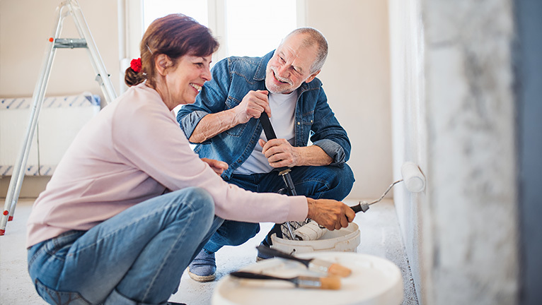 A couple painting a room in their house 