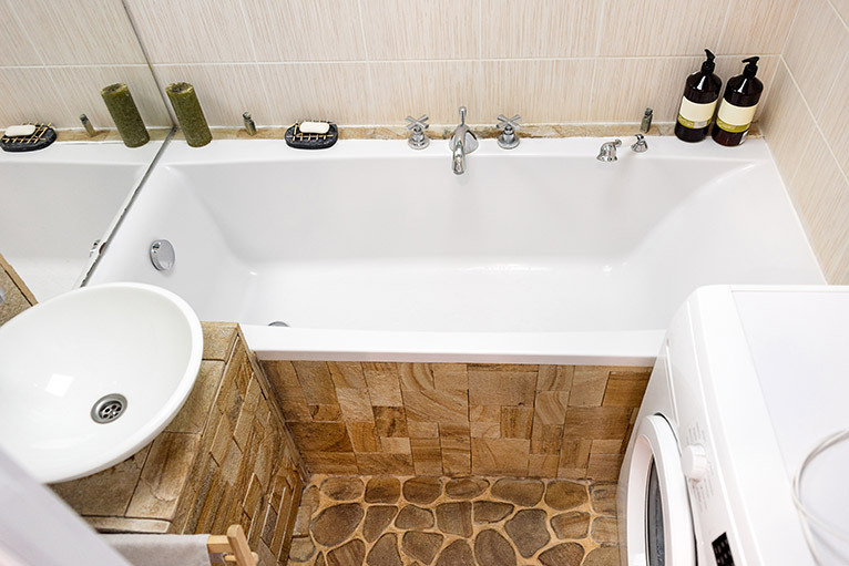 Small bathroom with sink, bath and washing machine
