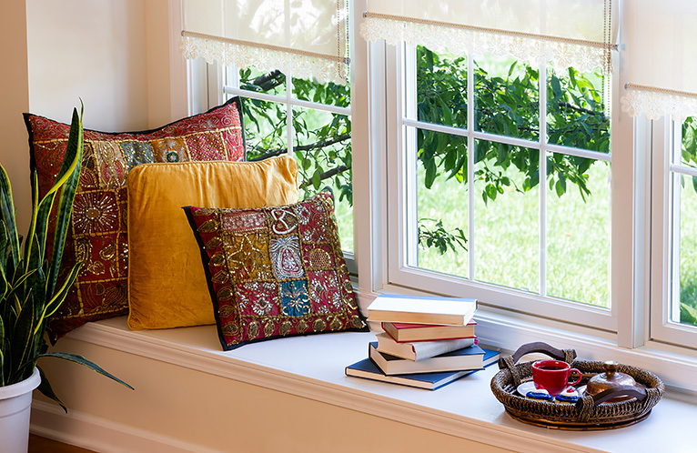 Window with cushions and books on a wide sill