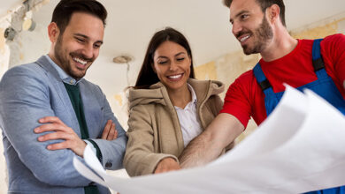 Three people discussing a blueprint