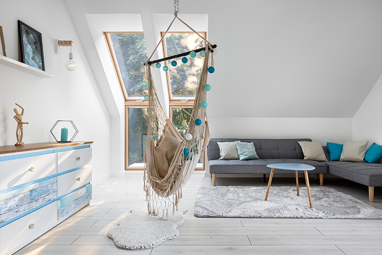 Bright living space loft conversion with a hanging chair and sofa