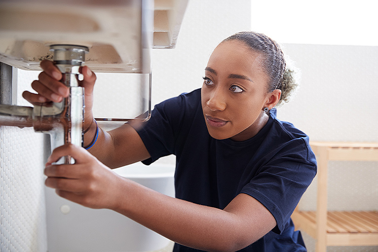 Female plumber working on a sink