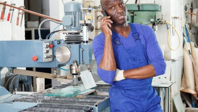 Tradesman in a workshop, talking on the phone