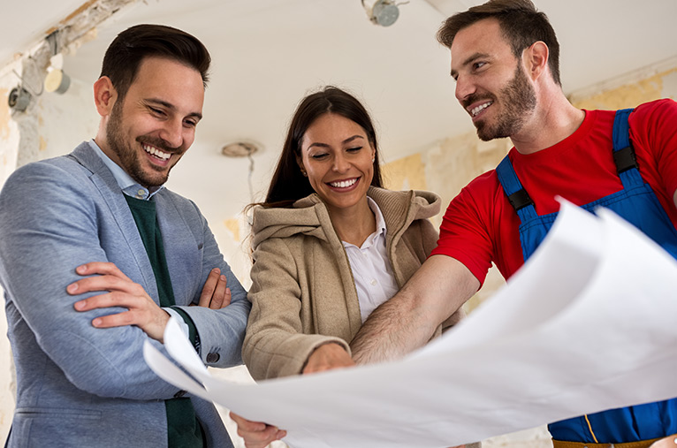 Smiling tradesperson showing smiling customers their plans