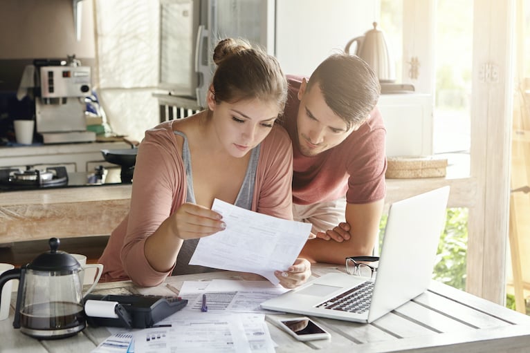 Couple looking at papers and laptop