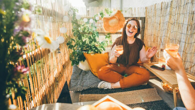 Smiling woman sitting on balcony cushions.