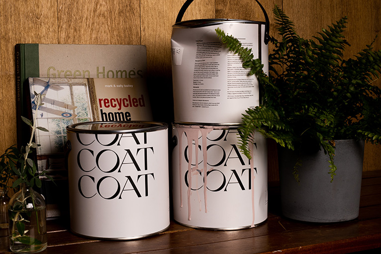 COAT paint cans with books and houseplants