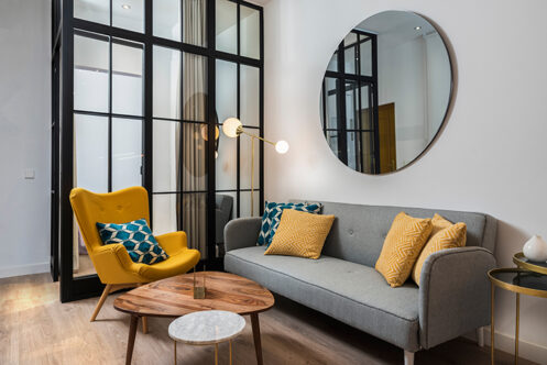 Oicture of a living room with a large round mirror