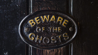 Picture of a sign on a door that says beware of the ghosts
