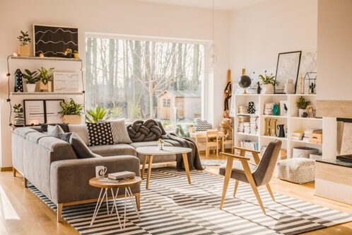 Picture of a living room with grey and wooden furniture and striped carpet