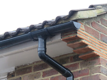 Picture of a black gutter pipe on outside of home