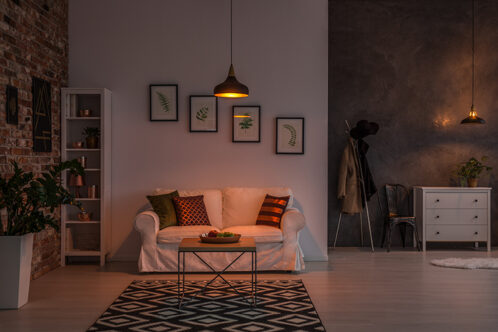 Picture of a living room with portraits hanging from the wall above the sofa