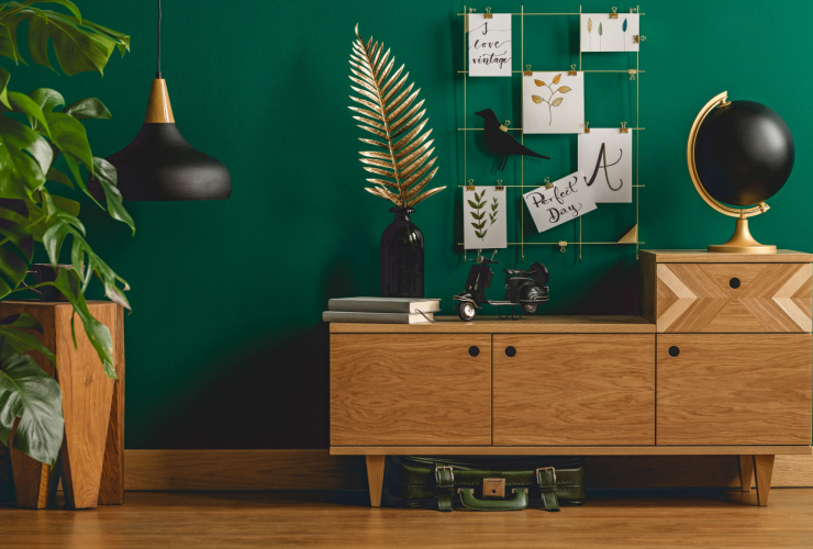 Picture of a green wall with wooden cabinet and other wall deocrations