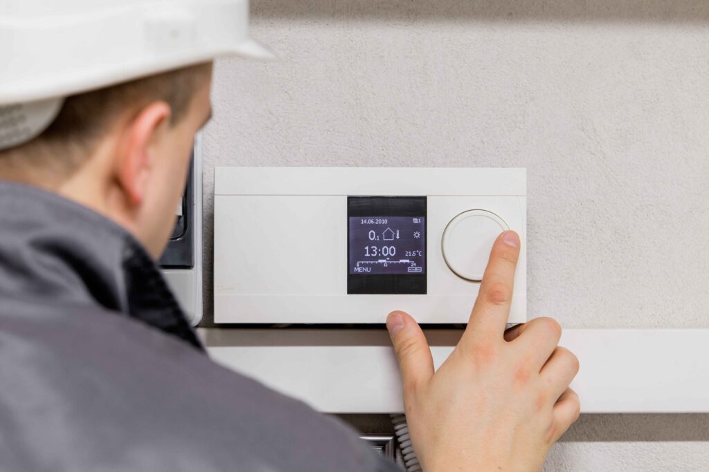 Picture of a heating engineer testing a smart thermostat
