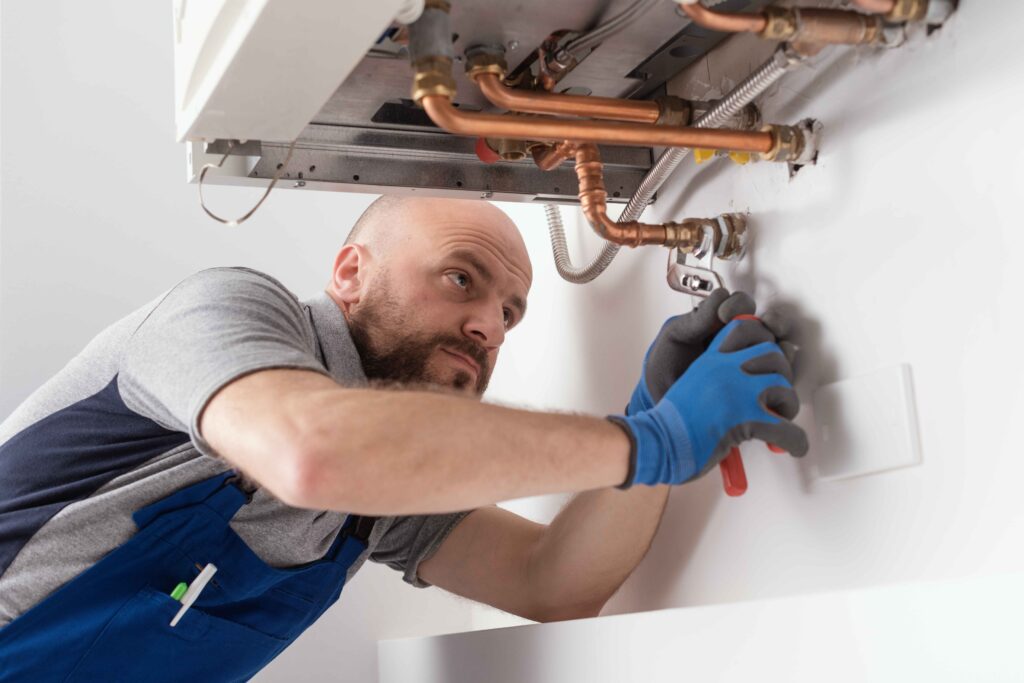 Picture of a boiler fitter and repair specialist installing a boiler