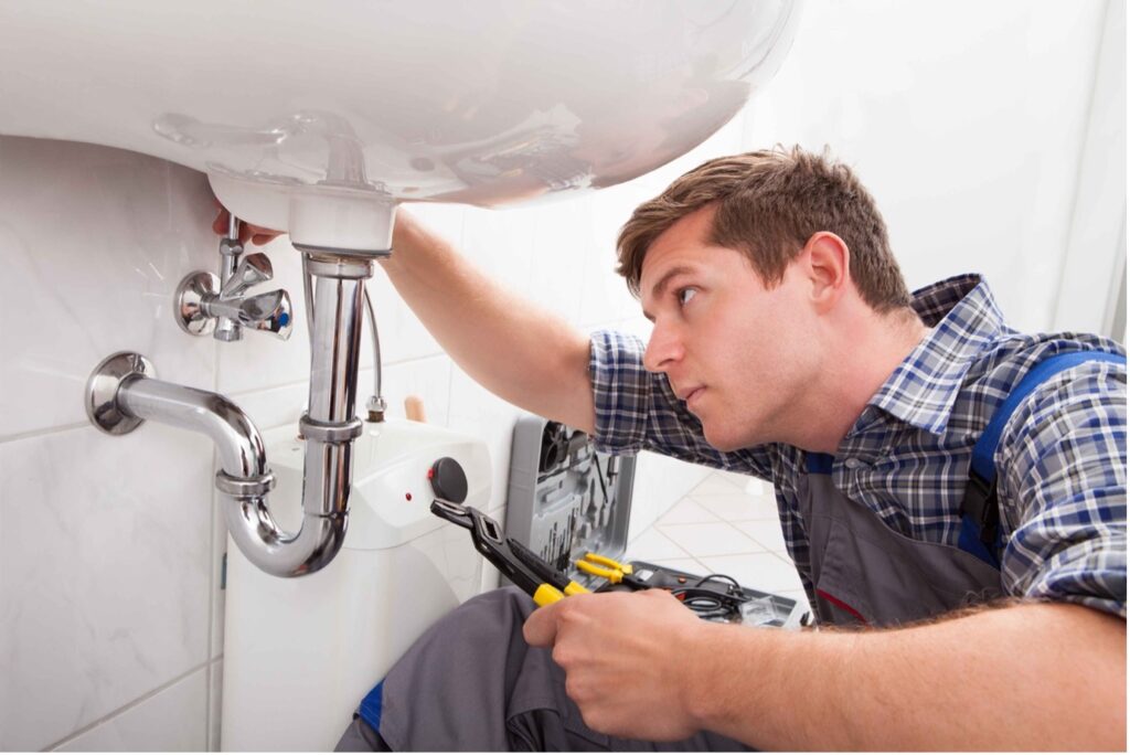 Picture of a plumber using tools to install a new bathroom sink