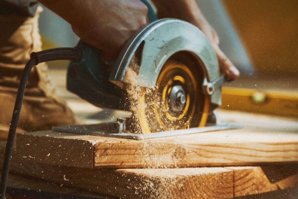 Picture of a carpenter using an electric saw to cut a piece of wood