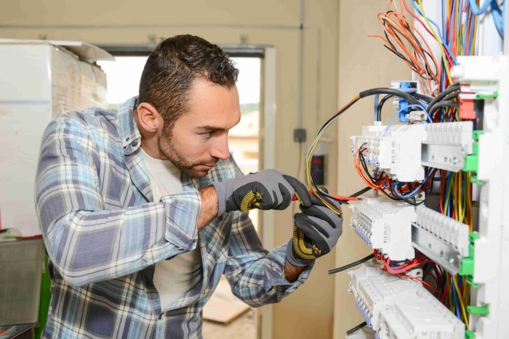 Picture of an electrician installing new electrics in a home using a screwdriver