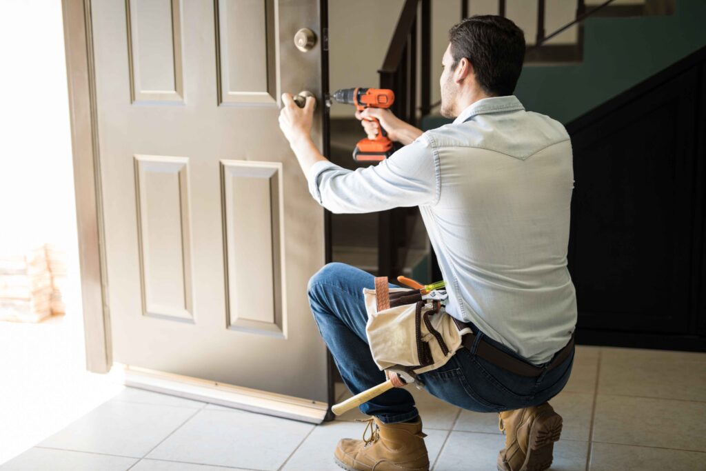 Picture of a handyperson installing a door handle using an electric screwdriver