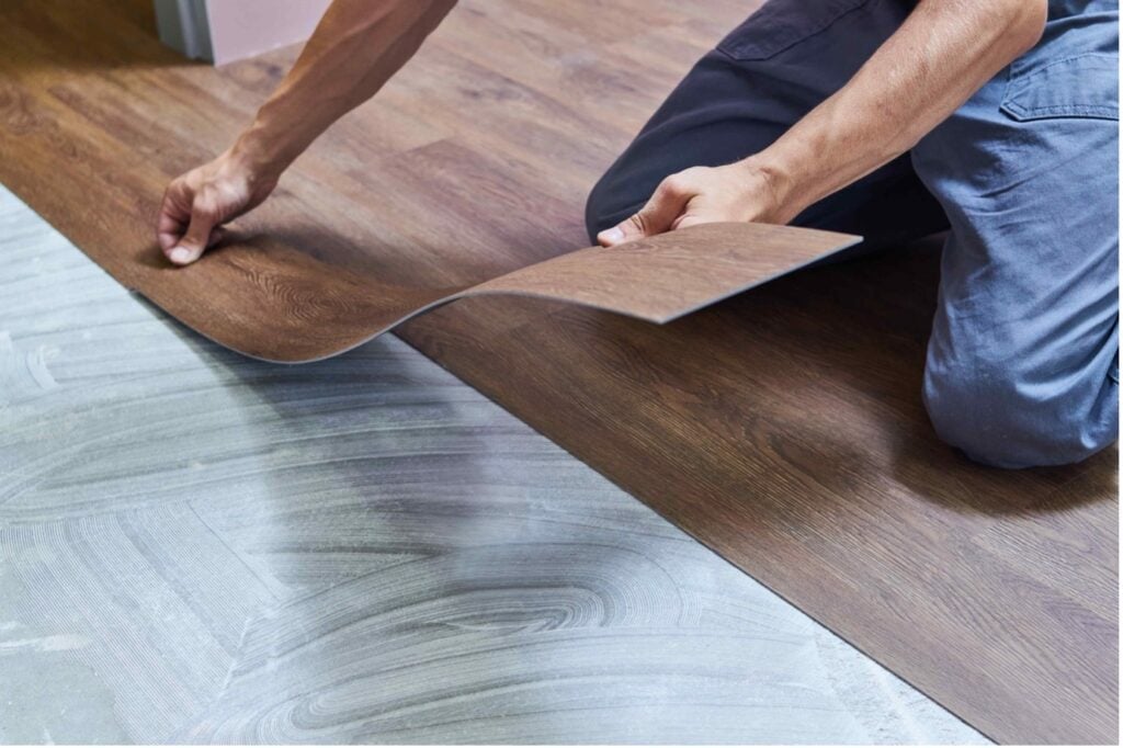 Picture of a flooring specialist installing a vinyl fake wood floor