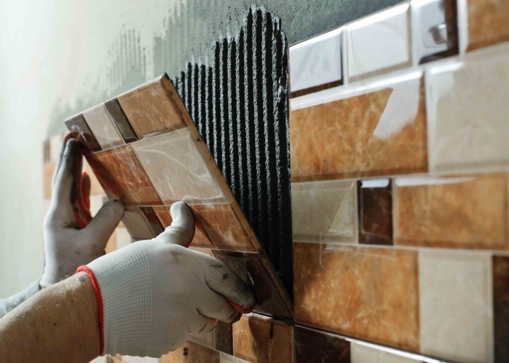 Picture of a tiling specialist installing new tiles to a wall