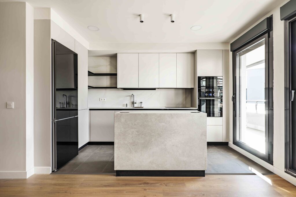 Picture of a modern kitchen with white cabinets, marble countertops and wooden floors