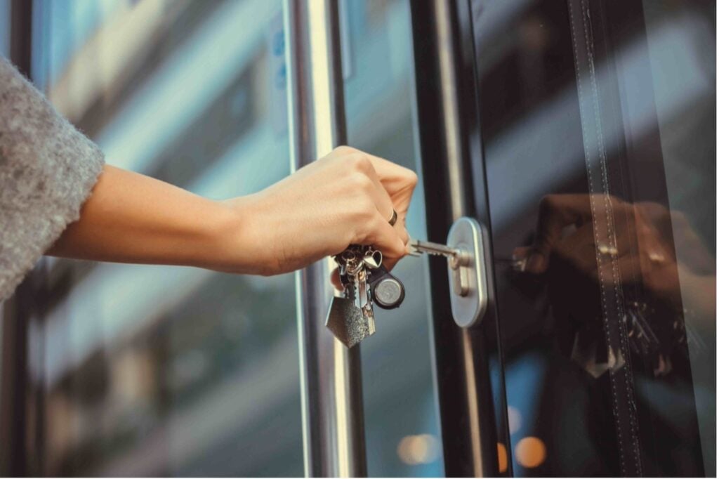 Picture of a woman’s hand putting a key into the lock of a front door