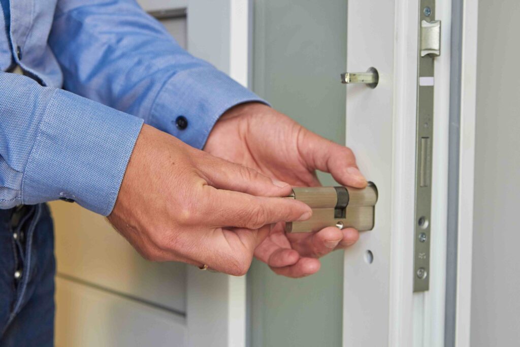 Picture of a man's hands installing a lock into a white frame internal door