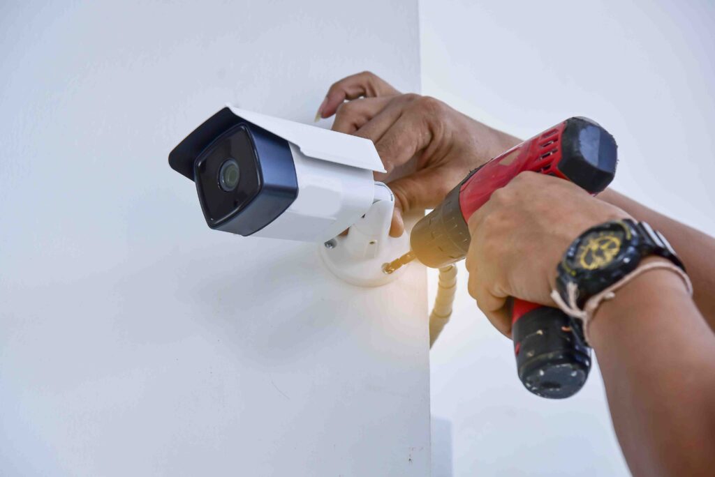 Picture of a security camera being installed with an electric screwdriver