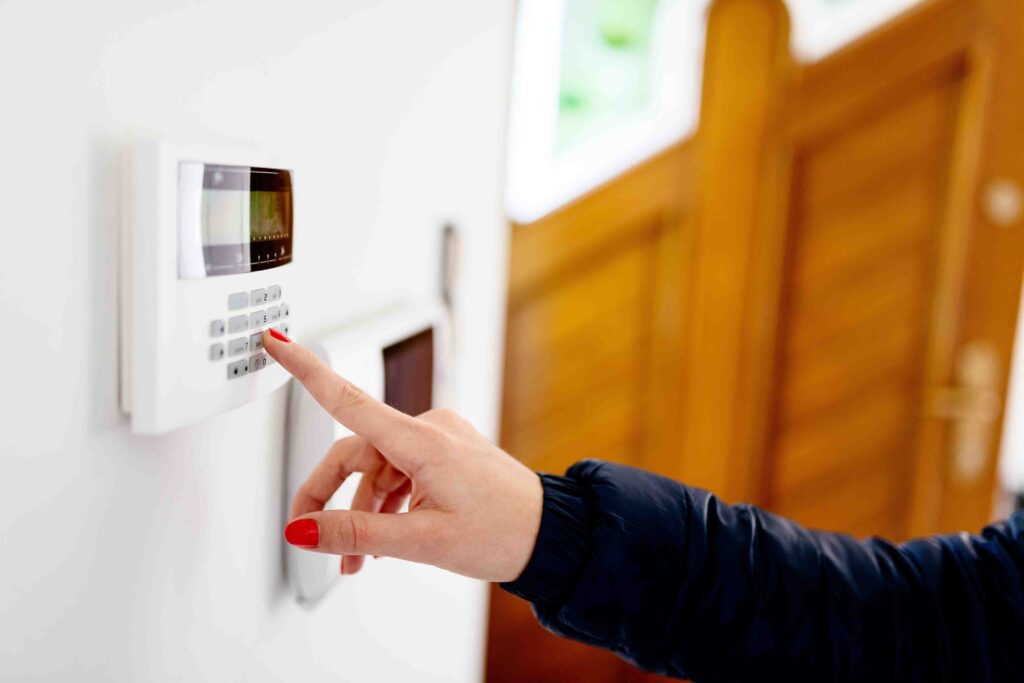 Picture of a woman enabling a security alarm inside her home