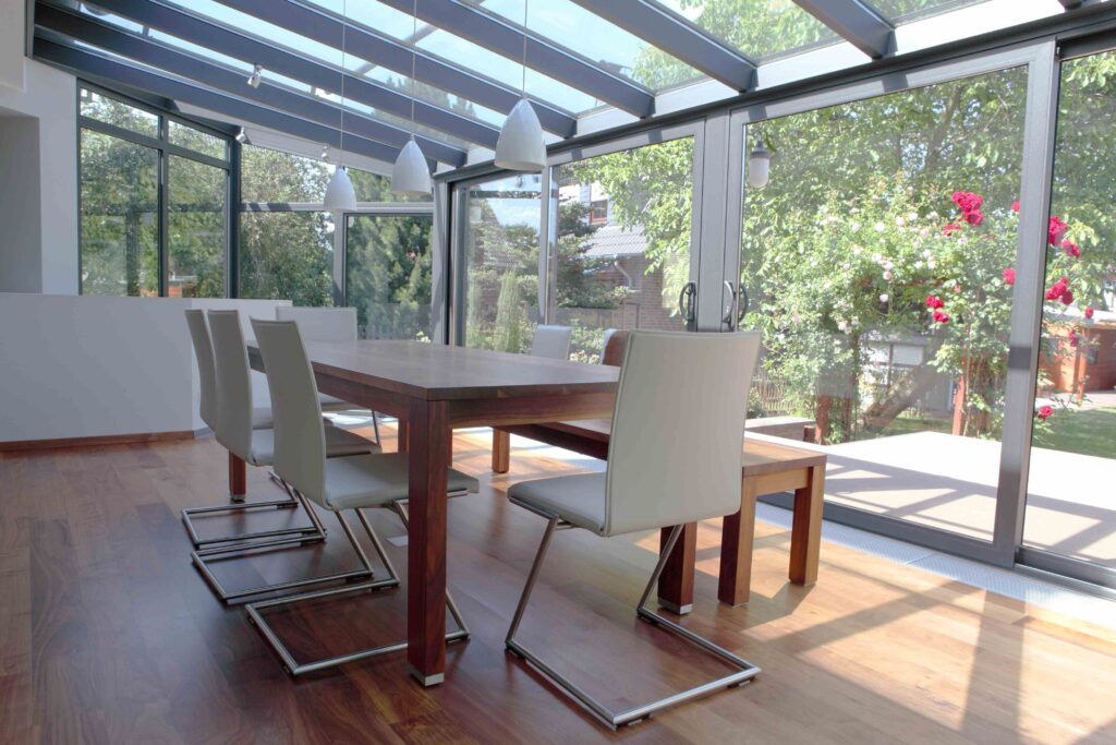 Picture of a conservatory with a wooden dining room table and cream chairs