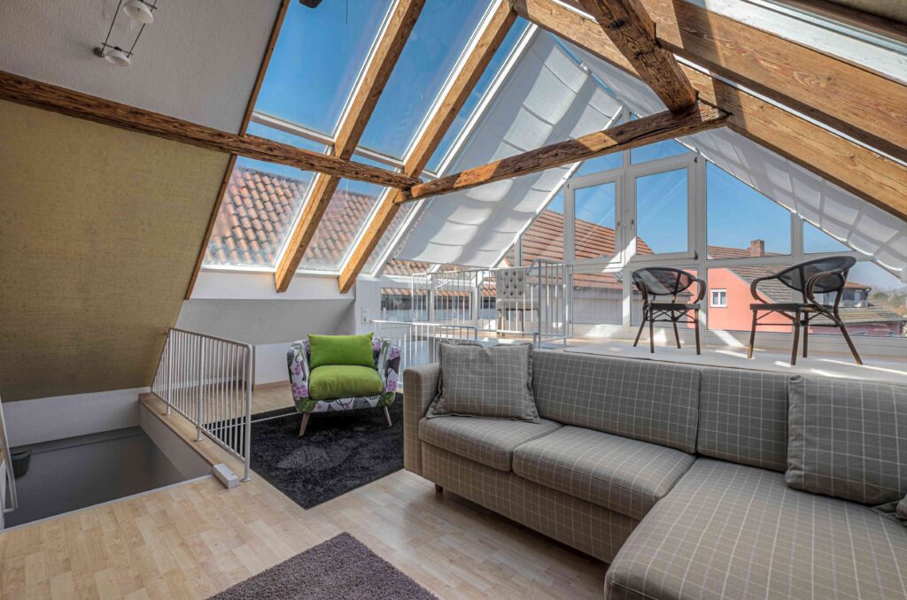 Picture of a modern loft conversion with chequered sofa and large velux windows