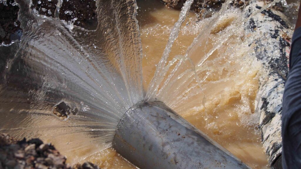 Picture of a burst pipe with water shooting out of it