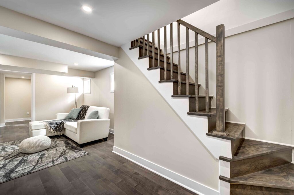 Picture of a basement converted into a living room with wooden staircase, wooden floors and cream coloured walls