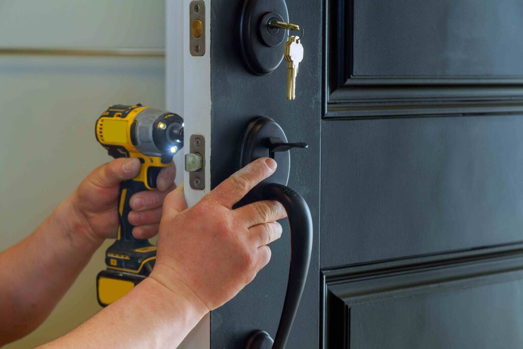 Picture of an emergency locksmith installing a new lock using an electric screwdriver