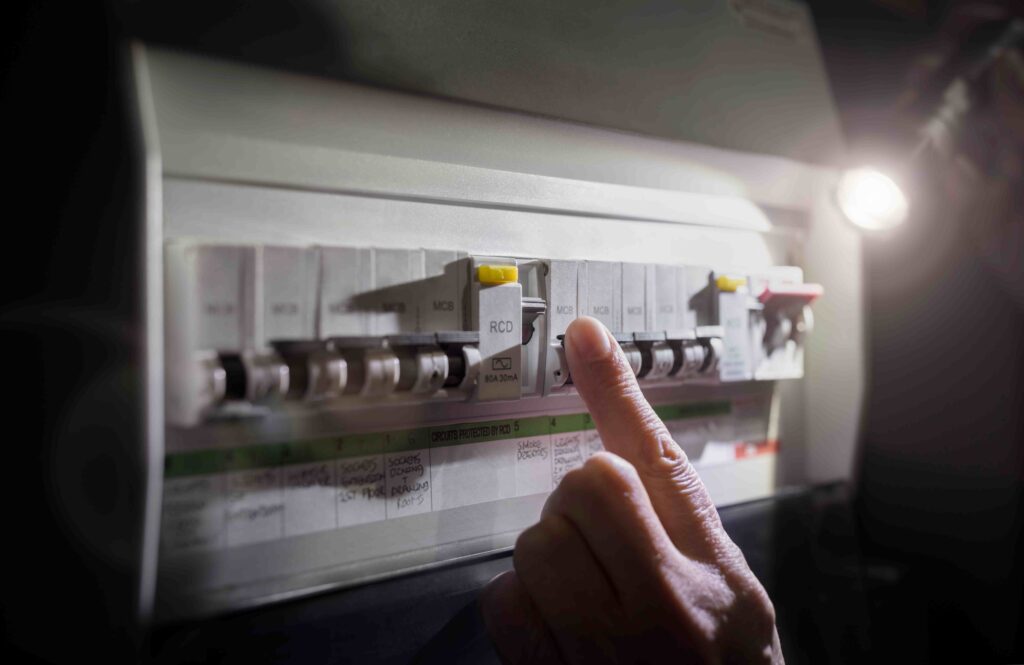 Picture of an electrician resetting a fuse box during a power cut